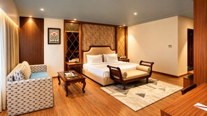 Ein Hotelzimmer mit Bett, Sofa, Sessel und einem kleinen Tisch.