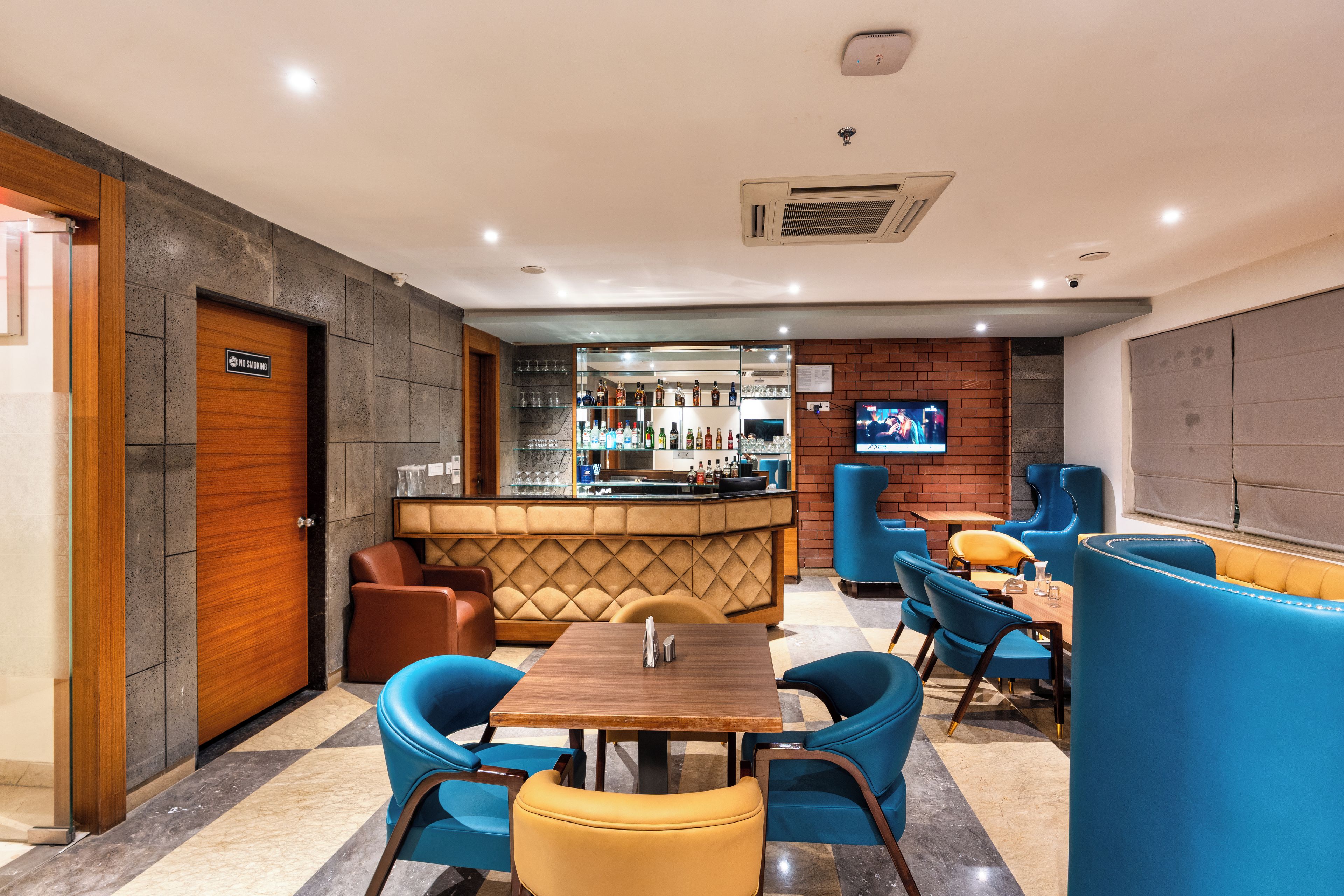 A bar area with seating and a television screen.