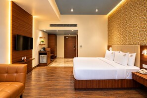 A modern hotel room with a large bed, a television, a desk, and a sofa. - Royal Aravali Udaipur (Udaipur)
