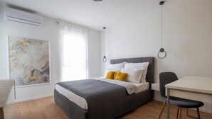 A modern bedroom with a bed, a desk, and a chair. - Modern 2BR Top Floor Apartment + Free Parking (Pula)