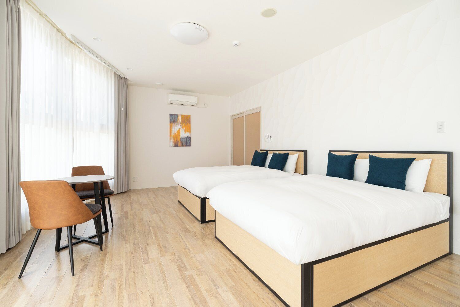 A hotel room with a bed, a desk, and a chair.