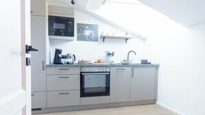 Een moderne keuken met een inbouwoven, magnetron en koffiezetapparaat.