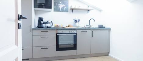 Eine moderne Küche mit Einbauofen, Mikrowelle und Kaffeemaschine.