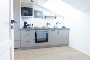 A modern kitchen with a built-in oven, microwave, and coffee maker.