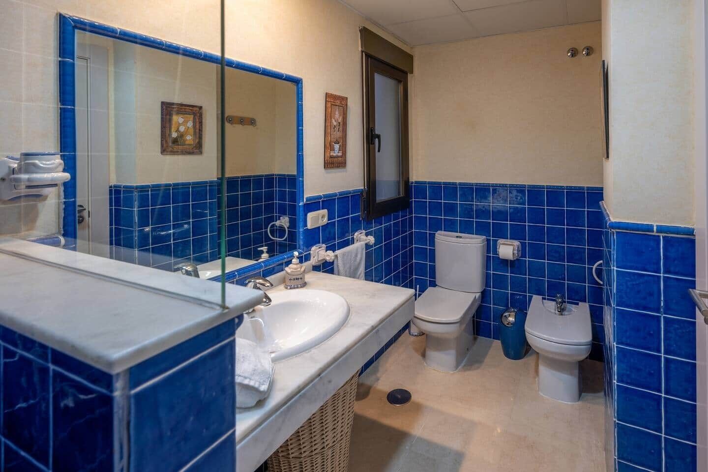 Un bagno con lavandino, specchio, WC e bidet.