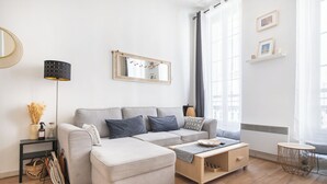 A modern living room with a sofa, coffee table, and a standing lamp. - Bohemian Studio Chic & Bright - Heart of Marseille (Marseille)