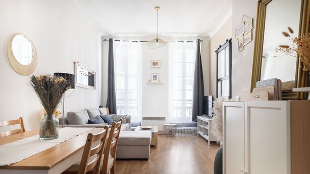 A modern living room with a dining area, a sofa, a TV, and a large mirror. - Bohemian Studio Chic & Bright - Heart of Marseille (Marseille)