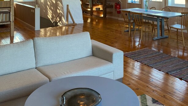 A spacious loft with high ceilings, exposed beams, a dining area with a table and chairs, and a cozy seating area with a sofa and coffee table. - Öland Idyll loft apartment close to the sea - swimming, surfing, kiting, hiking, cycling! (Mörbylanga)