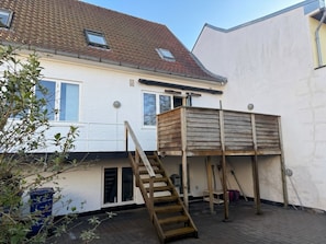 A two-story house with a wooden deck, a staircase, and a window. - Garden Suite - 1BR - Esbjerg Island (Esbjerg)