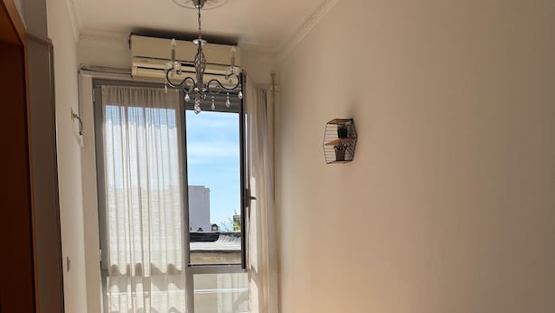 A bedroom with a bed, a window with curtains, a ceiling fan, and a wall-mounted light fixture. - Stay in a comfortable apartment - Valentino Apartment (Shkodër)