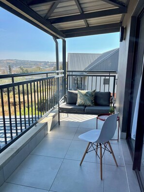 Un balcon avec un canapé, une table et des chaises.