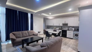Ein modernes Wohnzimmer mit einer Couch, einem Couchtisch und einem Essbereich mit Stühlen.