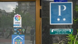 Een gebouw ingang met een parkeersbord, het logo van Etika en een bord met openingstijden.