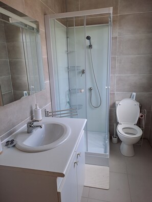 A modern bathroom with a glass-enclosed shower, a white sink, and a toilet. - Futuroscope Arena Ape Valley (Chasseneuil-du-Poitou)