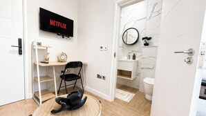 A modern bathroom with a toilet, sink, and mirror. - Exclusive Studio in the Heart of Hounslow! (Greater London)