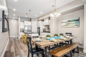 A modern kitchen with white cabinets, a central island, and pendant lighting. - Coral Ridge 2076, Near Golf Course, Community Amenities! (Washington)