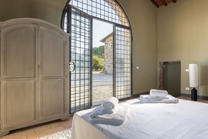 Ein Zimmer mit einem Bett, einem Schrank, einem Fenster mit Blick und einer Lampe.