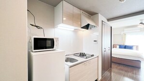 Cozinha compacta com micro-ondas, fogão e pia.