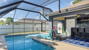 A swimming pool with a covered area, lounge chairs, and a patio with outdoor furniture. - Patio & Poolside Relaxation! Palm Coast Getaway (Palm Coast)