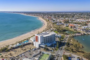 A coastal hotel with a pool, tennis court, and a view of the beach and ocean. - Coastal Studio | City & Ocean Views, Walk to Beach (Mandurah)