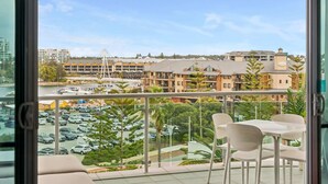 A balcony with a view of a parking lot, buildings, and a bridge. - Coastal Studio | City & Ocean Views, Walk to Beach (Mandurah)