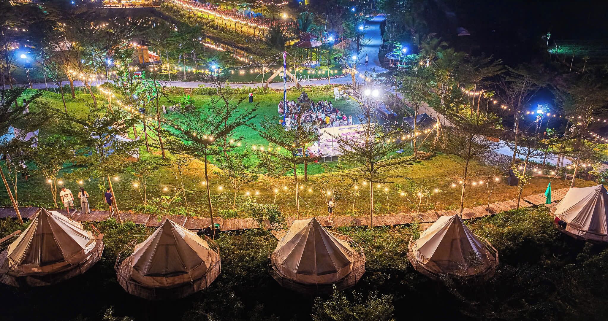 A campsite with tents, a central gathering area, and string lights.