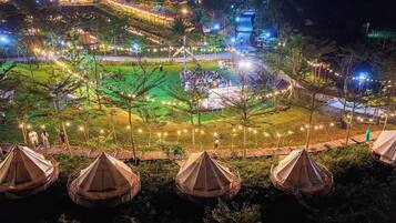A campsite with tents, a central gathering area, and string lights.
