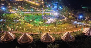 Ein Campingplatz mit Zelten, einem zentralen Treffpunkt und Lichterketten.