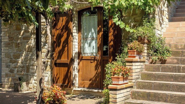 A stone building with a wooden door, a wooden staircase, and potted plants. - Apartment in Castel D'arno with 1 bedrooms sleeps 2 (Castel D'arno)