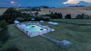 A rectangular outdoor pool with lounge chairs and umbrellas, surrounded by a grassy area and fields. - Apartment in Castel D'arno with 1 bedrooms sleeps 2 (Castel D'arno)