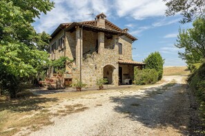 A stone building with a covered porch, a gravel driveway, and surrounding greenery. - Apartment in Castel D'arno with 1 bedrooms sleeps 3 (Castel D'arno)