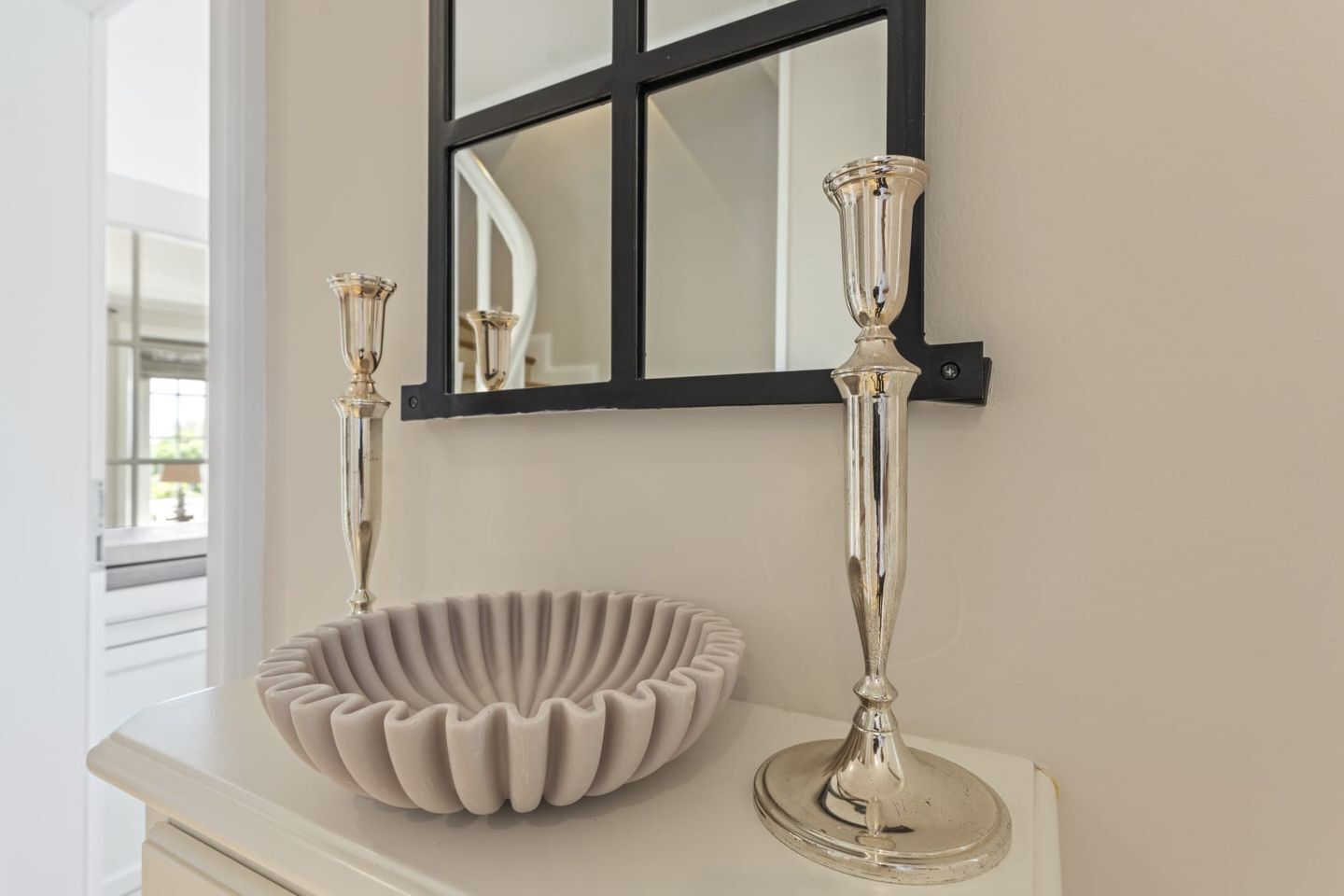 A bathroom vanity with a white basin and two tall, slender candle holders.