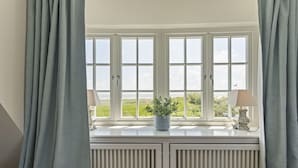 A room with a bay window, a radiator, and a potted plant on the windowsill.