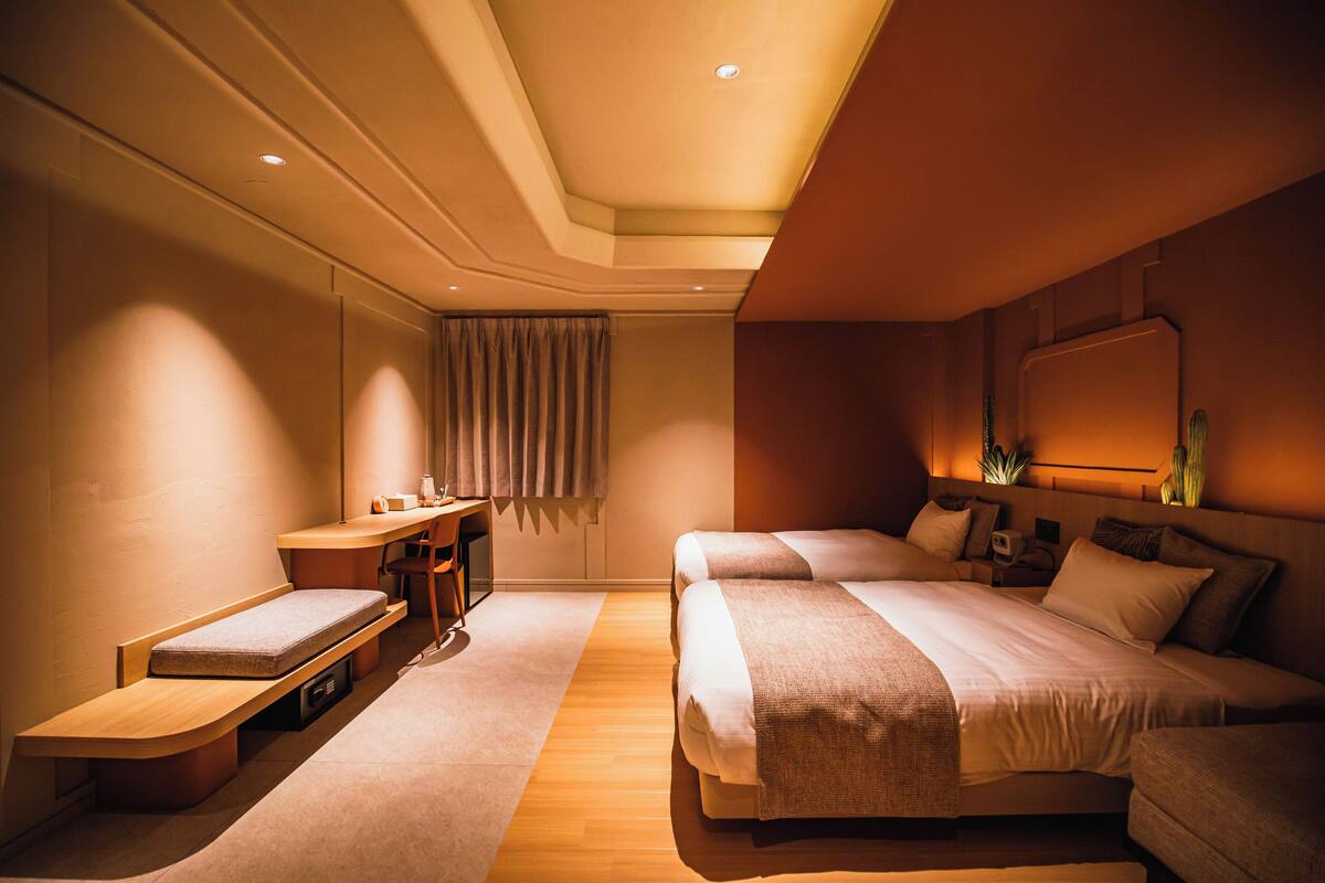 Una habitación de hotel con una cama, un escritorio, una silla y una mesita.