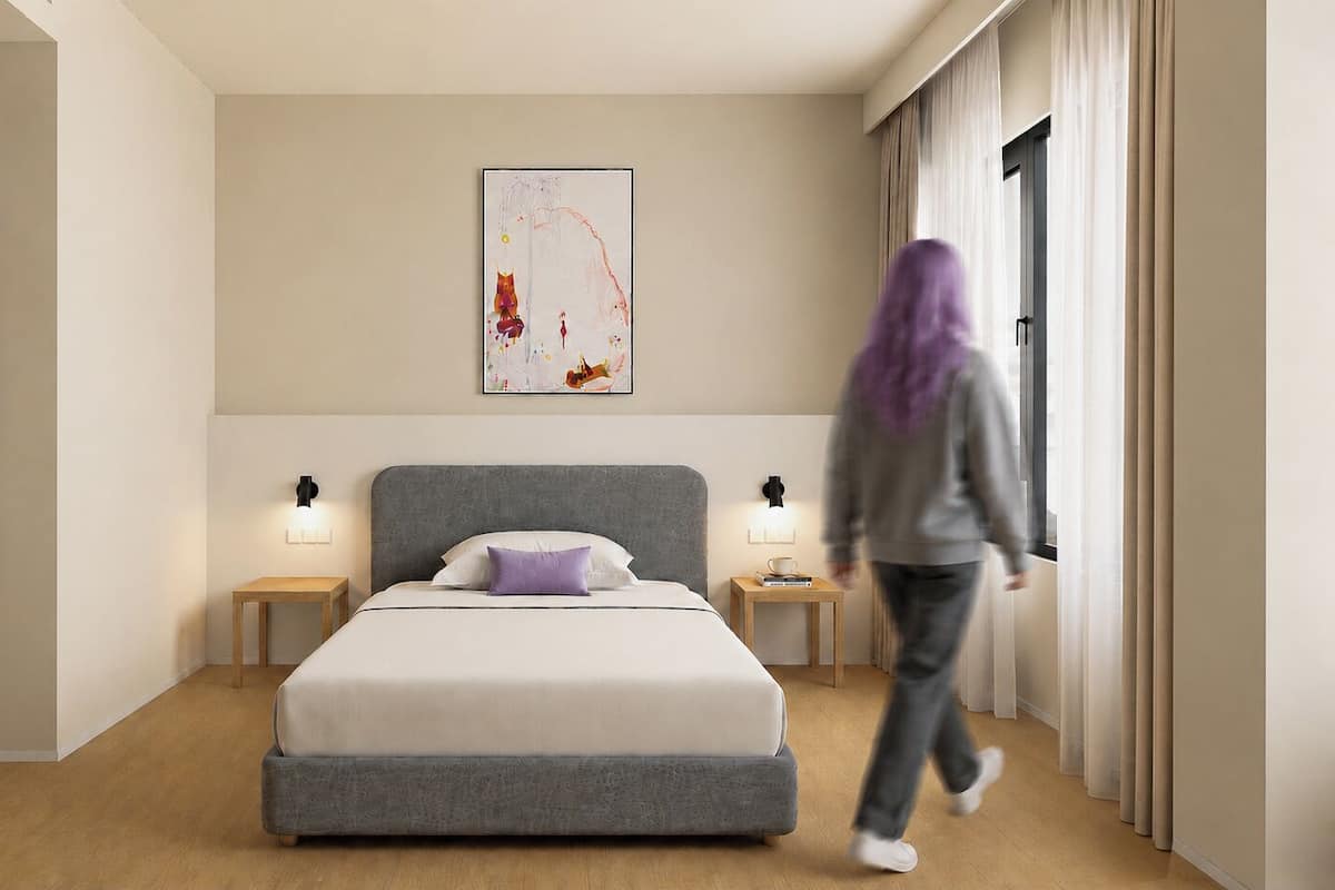 Ein modernes Schlafzimmer mit einem Bett, Nachttischen, einem Wandbild und einer sich bewegenden Person.
