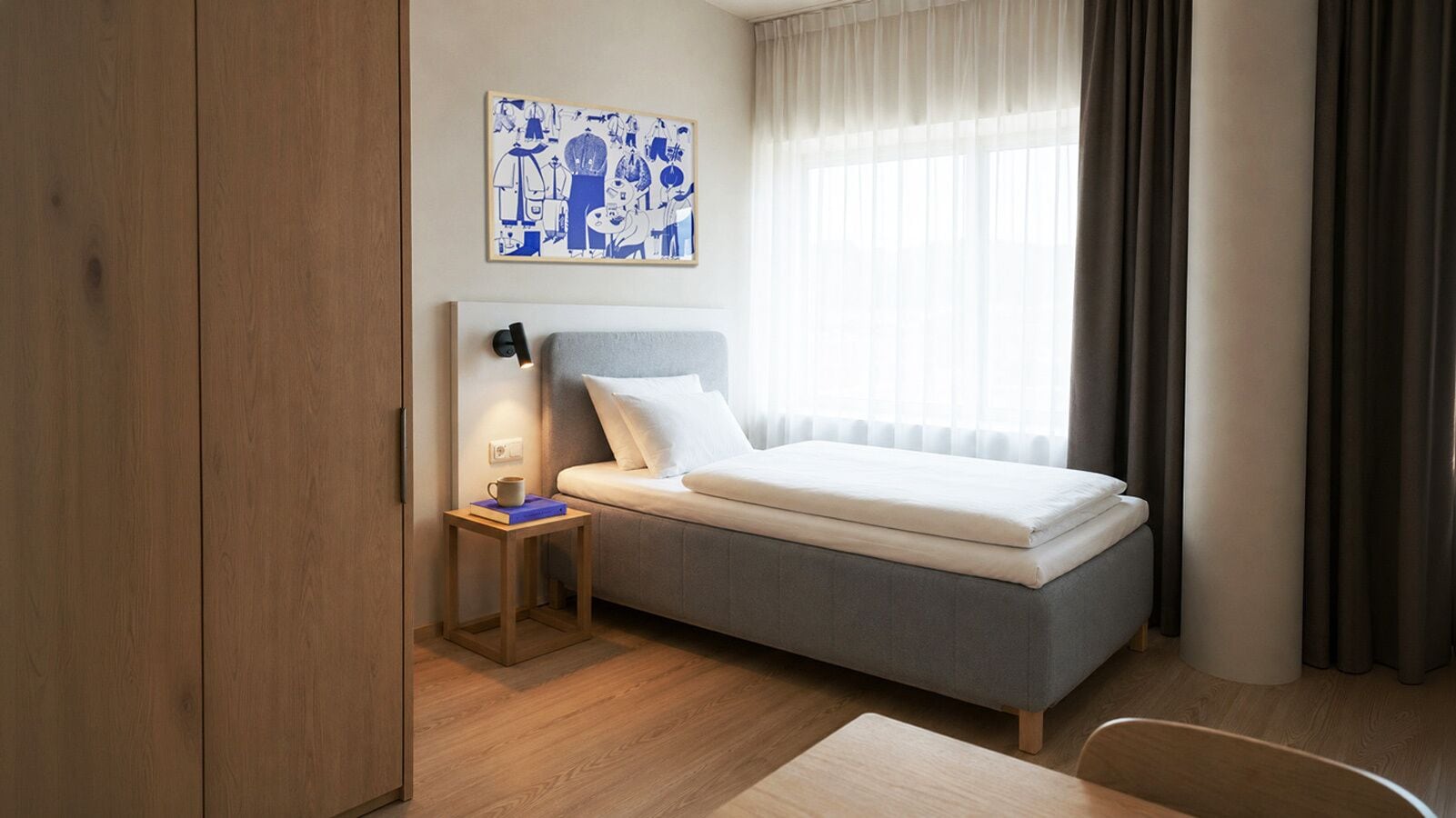Una habitaci ón de hotel con cama, mesita de noche, lámpara, ventana con cortinas y una obra de arte en la pared.