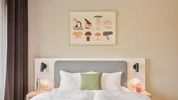 Een hotelkamer met een bed, twee nachtkastjes, een kunstwerk aan de muur en een raam met gordijnen.