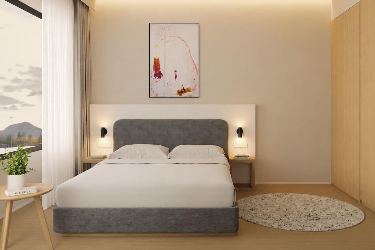 Ein modernes Hotelzimmer mit einem großen Bett, Nachttischen, Bergblick und einer kleinen Küchenzeile.