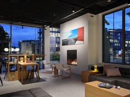 Un interior moderno con chimenea, zona de estar y ventanas amplias con vistas a la ciudad.