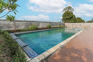 A rectangular swimming pool with clear water, surrounded by a wooden fence and a tiled deck. - Cozy Double Escape W/ Free WiFi and Parking (Bekasi)