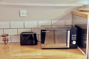 A kitchen with a toaster, a microwave, and a coffee maker on the counter.