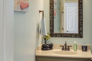A bathroom with a sink, mirror, towel rack, and decorative items. - Getaway 1 Mi to Sligo Marina & Center Hill Lake! (Smithville)