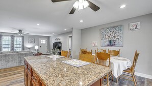 A kitchen with granite countertops, wooden cabinets, a dining area with a table and chairs, and a ceiling fan. - 3 Mi to Nolin Lake Boat Ramp! Family Home w/ Deck (Mammoth Cave)