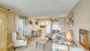 Un salon comprenant un canapé, un fauteuil, une table basse et un coin repas avec des chaises et une table.