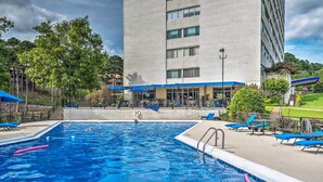 Une piscine avec des chaises longues et un bâtiment en arrière-plan.