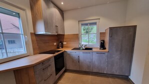 Una cocina moderna con lavavajillas, cafetera y ventana.