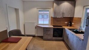 Una cocina moderna con comedor, ventana con vistas y horno empotrado.