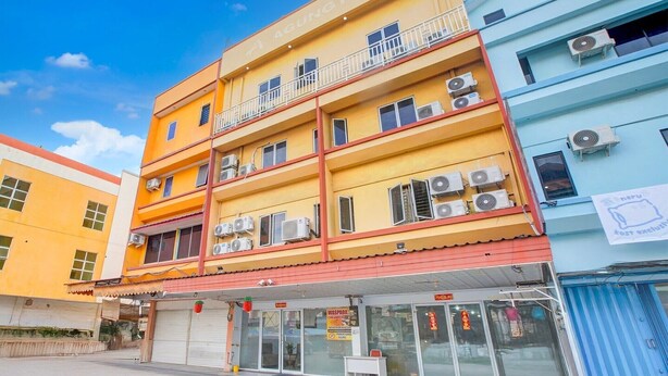 A multi-story hotel with balconies, air conditioning units, and a visible storefront.
