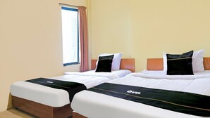 Twee bedden met bijpassende hoofdborden en voetenborden, een raam met gordijn, en een betegelde vloer.
