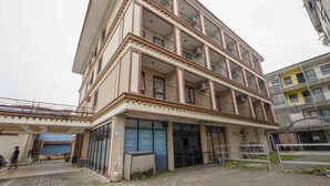 Un edificio a più piani con balconi, ampie finestre e un’area d'ingresso coperta.